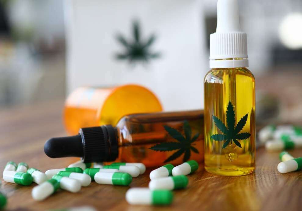 ผลข้างเคียงของ CBD Cannabis oil and precsription drugs on a table