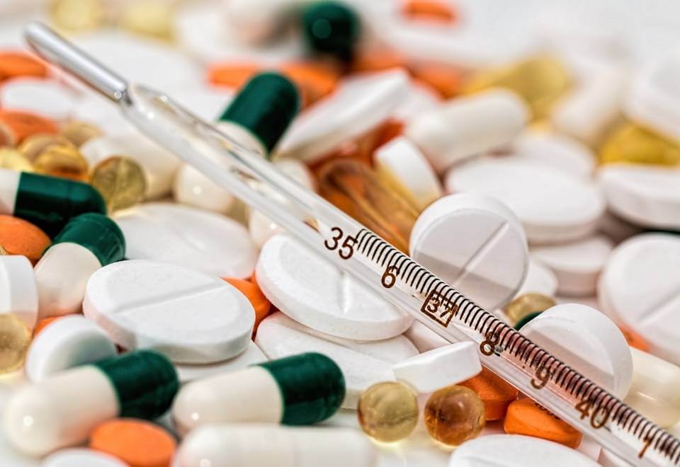 Closeup on pills and drug needle