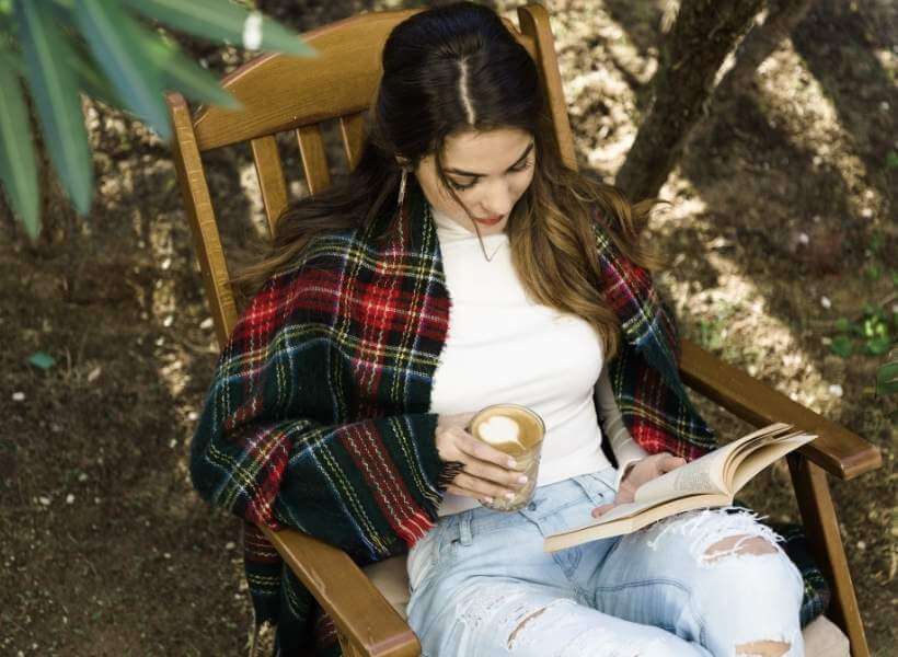 Brunette woman drinking coffe and reading