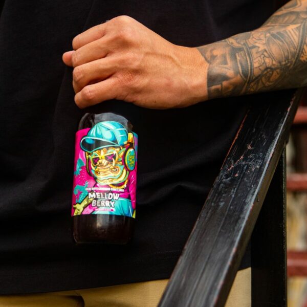 Local Boys THC Craft Soda - Mellow Berry Flavor product photo held by model with tattoos
